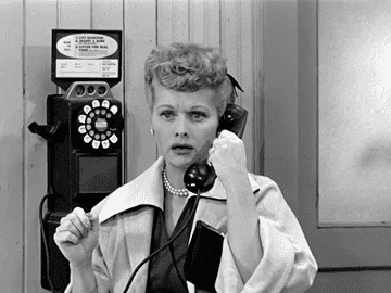 Lucille Ball talking on a rotary wall phone