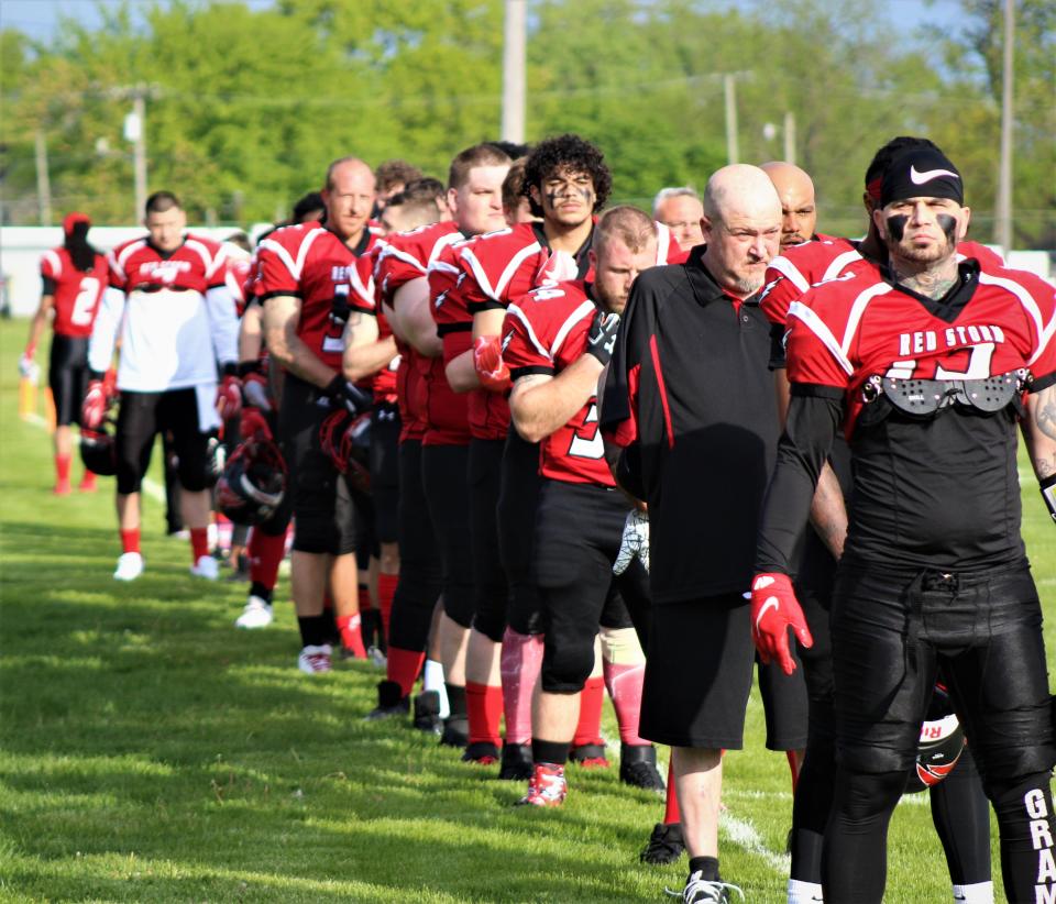 Players and staff for the Southeast Michigan Red Storm stand on the sideline during the National Anthem on Saturday, May 15, 2021.