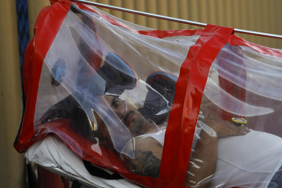 A patient encased in a protective plastic tube and receiving supplemental oxygen is wheeled into the COVID-19 triage unit at Mexico General Hospital, in Mexico City, Monday, May 25, 2020. Authorities have predicted that coronavirus cases in the city would peak in May, with reopening measures currently slated for mid-June. (AP Photo/Rebecca Blackwell)