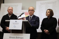 Attorney Jeff Anderson speaks as Joe Iacono, left, and Cindy Yesko listen during a news conference with , Wednesday, March 20, 2019, in Chicago. Advocates for clergy abuse victims say their list of 395 priests or lay people in Illinois who have been publicly accused of sexually abusing children is far more extensive than the names already released by the state's six dioceses. (AP Photo/Kiichiro Sato)