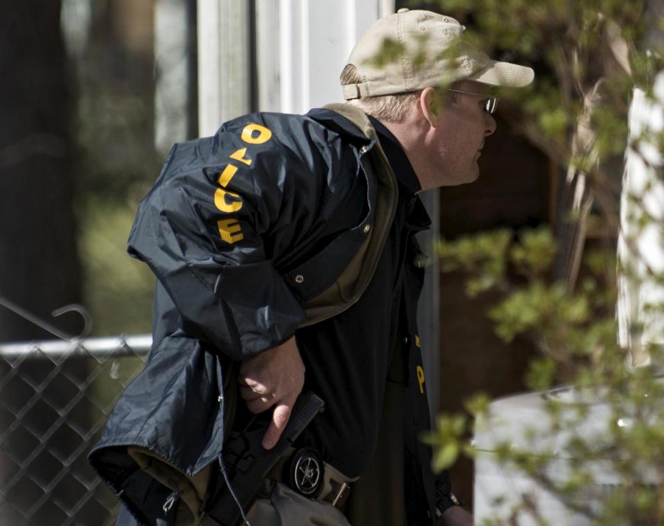 An officer from the U.S. Marshals fugitive task force hunts for accused bank robber Wossen Assaye, who escaped Inova Fairfax Hospital early Tuesday in Fairfax, Virginia March 31, 2015. The armed prisoner was on the run in a stolen car on Tuesday after escaping from the northern Virginia hospital where a shot was fired during a struggle with a guard, police said. Assaye, 42, broke free from a private security guard at the Inova Fairfax Medical Campus in Falls Church, Virginia, and fled with the guard's weapon, the Fairfax County Police Department said on its Twitter account. (REUTERS/James Lawler Duggan)