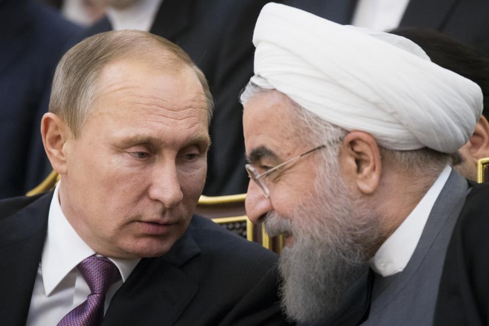 FILE - Russian President Vladimir Putin, left, and Iran's President Hassan Rouhani talk to each other as they attend a signing ceremony during the Gas Exporting Countries Forum (GECF) in Tehran, Iran, Monday, Nov. 23, 2015. Putin declared earlier this month that Moscow could play the role of mediator to help end the Israel-Hamas war, thanks to its friendly ties with both Israel and the Palestinians, adding that "no one could suspect us of playing up to one party." (AP Photo/Alexander Zemlianichenko, File)