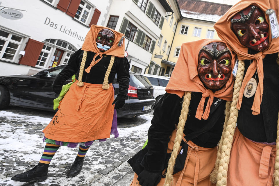 Some carnival fools of the Schwarze Veri Zunft Ravensburg walk through the Obertor gate in Ravensburg, Germany, Monday, Feb. 15, 2021. The police broke up the gathering immediately afterwards. (Felix Kaestle/dpa via AP)