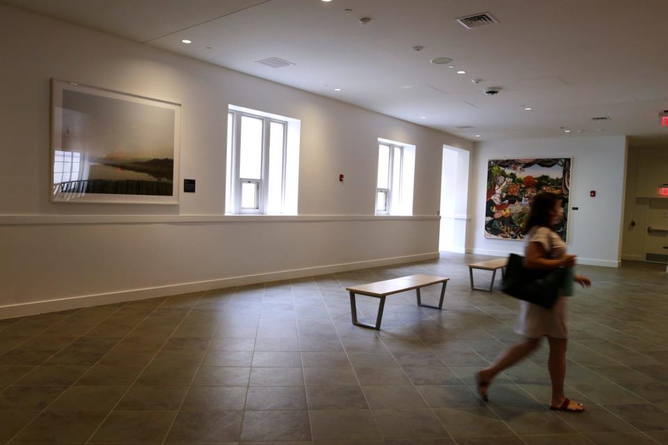 A library patron walks through an upper-level hallway. Art displays by members of the community are an important element of the library's redesign.