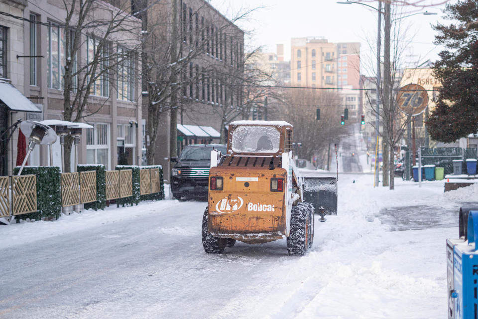 Snow plows plow the roads of downtown Asheville on January 17, 2021.