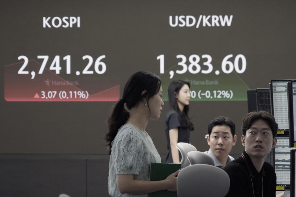 Currency traders work near the screen showing the Korea Composite Stock Price Index (KOSPI), top left, and the foreign exchange rate between U.S. dollar and South Korean won at the foreign exchange dealing room of the KEB Hana Bank headquarters in Seoul, South Korea, Wednesday, July 31, 2024. (AP Photo/Ahn Young-joon)