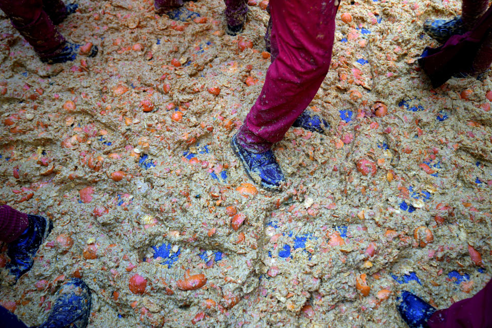 Smashed oranges are scattered on the ground during the 'Battle of the Oranges" where people pelt each other with oranges as part of Carnival celebrations in the northern Italian Piedmont town of Ivrea, Italy, Tuesday, Feb. 13, 2024. (AP Photo/Antonio Calanni)