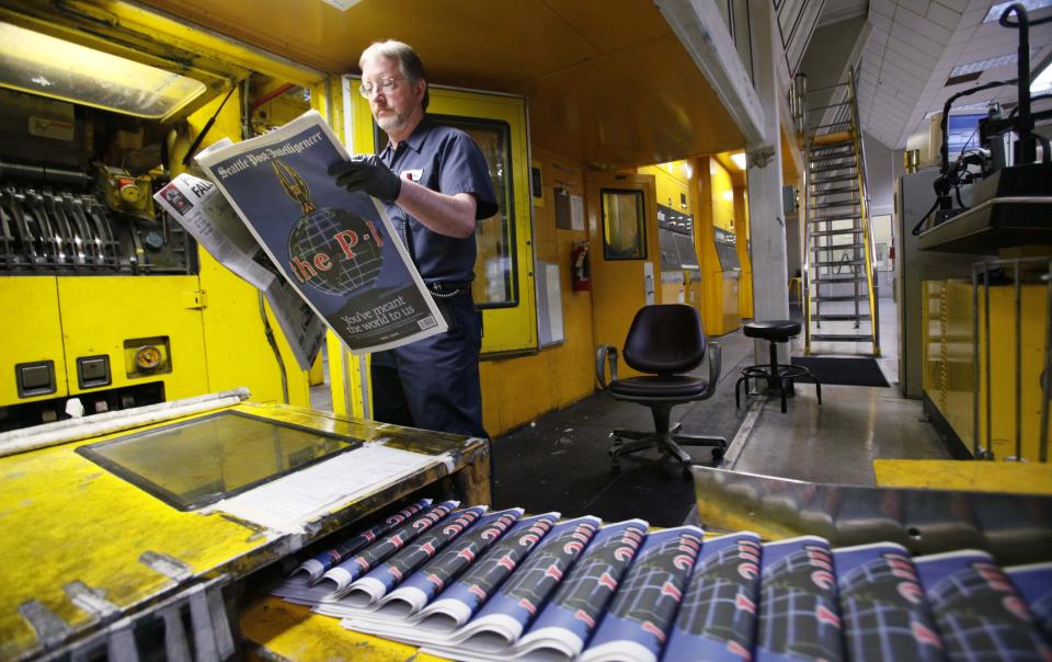 FILE - Pressman Jim Herron looks over a final edition of the Seattle Post-Intelligencer as it comes off the press on March 16, 2009, at the printing plant in Bothell, Wash. The 146-year-old paper printed its final edition on March 17, 2009. The decline of local news in the United States is speeding up despite attention paid to the issue, to the point where the nation has lost one-third of its newspapers and two-thirds of its newspaper journalists since 2005. (AP Photo/Elaine Thompson, File)