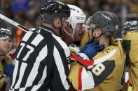 ADDS NAME OF OFFICIAL - Linesman Caleb Apperson (77) attempt to break up a fight between Colorado Avalanche defenseman Josh Manson, center, and Vegas Golden Knights center Tomas Hertl (48) during the second period of an NHL hockey game Sunday, April 14, 2024, in Las Vegas. (AP Photo/Ian Maule)