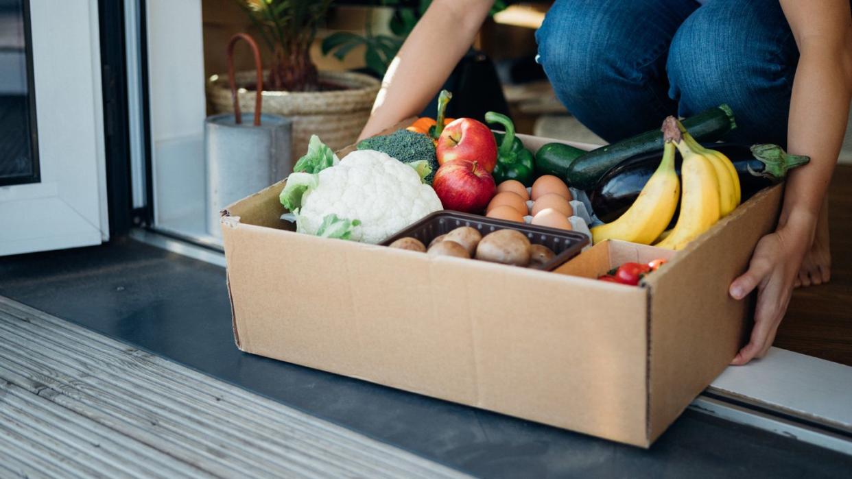 young woman receiving fresh food home delivery