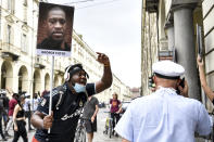 A man holding a picture of George Floyd attends a flash mob calling for justice for George Floyd, who died May 25 after being restrained by police in Minneapolis, USA, in Turin, Italy, Saturday, June 6, 2020. Several hundred people have protested peacefully in Turin, Italy, to denounce the police killing of George Floyd and show solidarity with anti-racism protests in the U.S. and elsewhere. (Fabio Ferrari/LaPresse via AP)