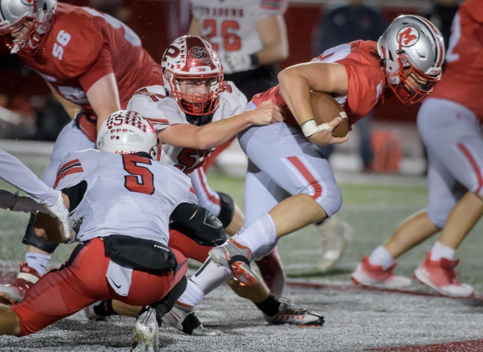 Morton's Brett Michel tries to pull away from Pekin's Brayden Hoover (52) and Connor Drowns (5) in the second half Friday, Sept. 23, 2022 at Carper Field in Morton.