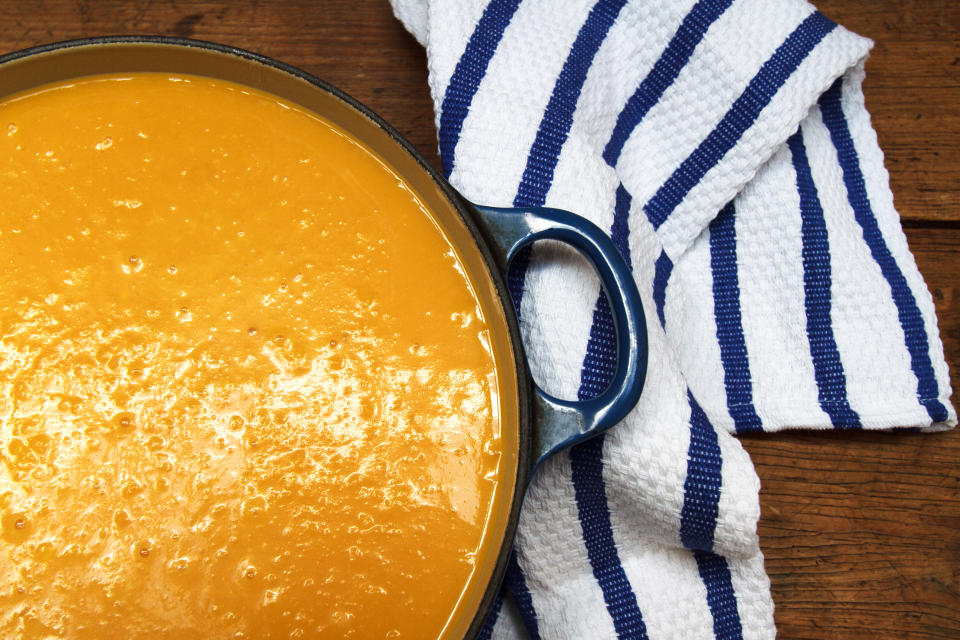 Pot of squash-carrot soup and striped towel.