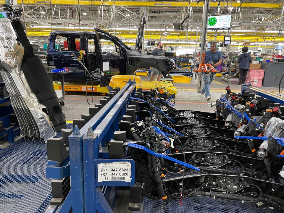 Factory worker installs parts on the F-150 Lightning assembly line.