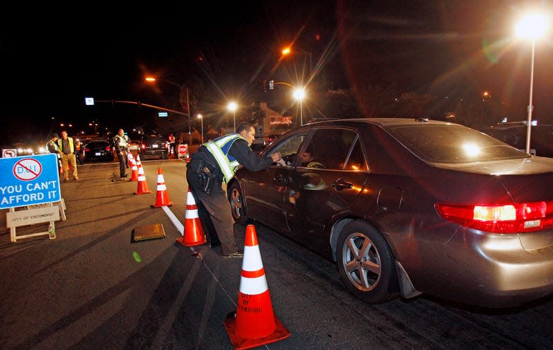 A police officer speaks to the driver of a silver sedan at a DUI checkpoint in Escondido California on December 16, 2011