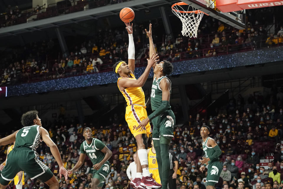 Minnesota forward Eric Curry, left, shoots over Michigan State guard Marcus Bingham Jr. during the first half an NCAA college basketball game Wednesday, Dec. 8, 2021, in Minneapolis. (AP Photo/Craig Lassig)