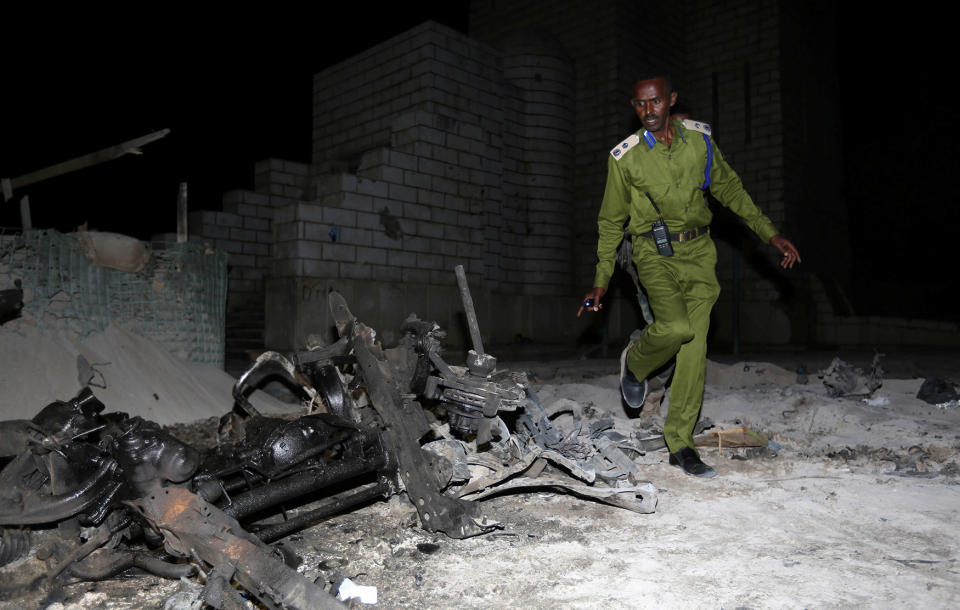 Somali policeman inspects suicide car explosion