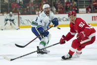 Vancouver Canucks defenseman Kyle Burroughs (44) passes around Detroit Red Wings center Vladislav Namestnikov (92) in the second period of an NHL hockey game Saturday, Oct. 16, 2021, in Detroit. (AP Photo/Paul Sancya)