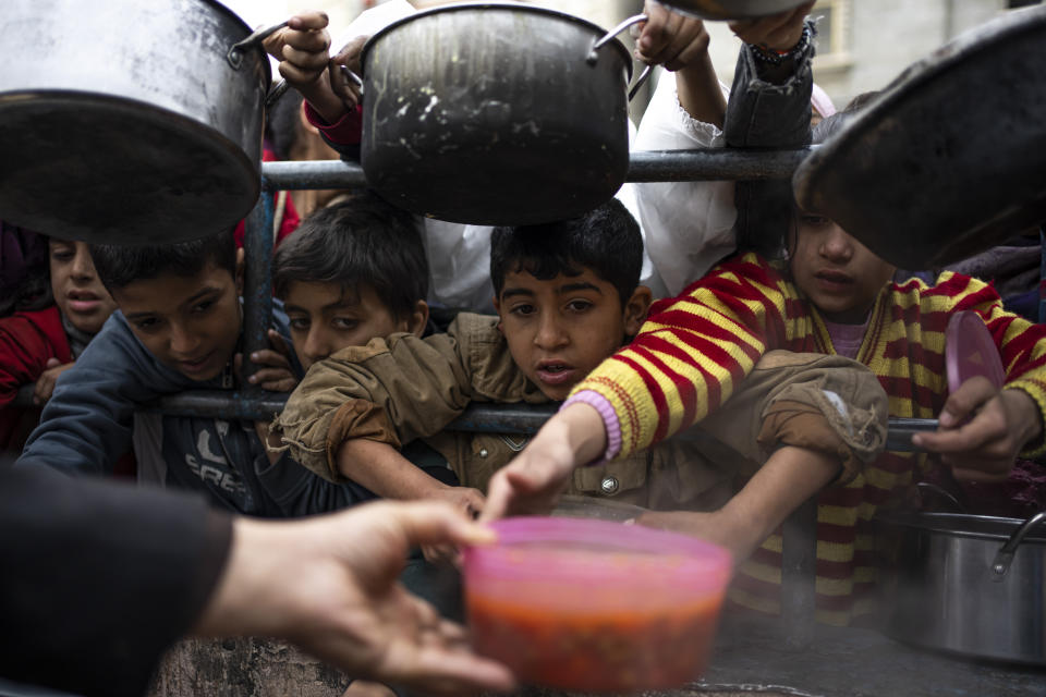 Palestinians line up for a free meal in Rafah, Gaza Strip, Friday, Feb. 16, 2024. International aid agencies say Gaza is suffering from shortages of food, medicine and other basic supplies as a result of the war between Israel and Hamas. (AP Photo/Fatima Shbair)