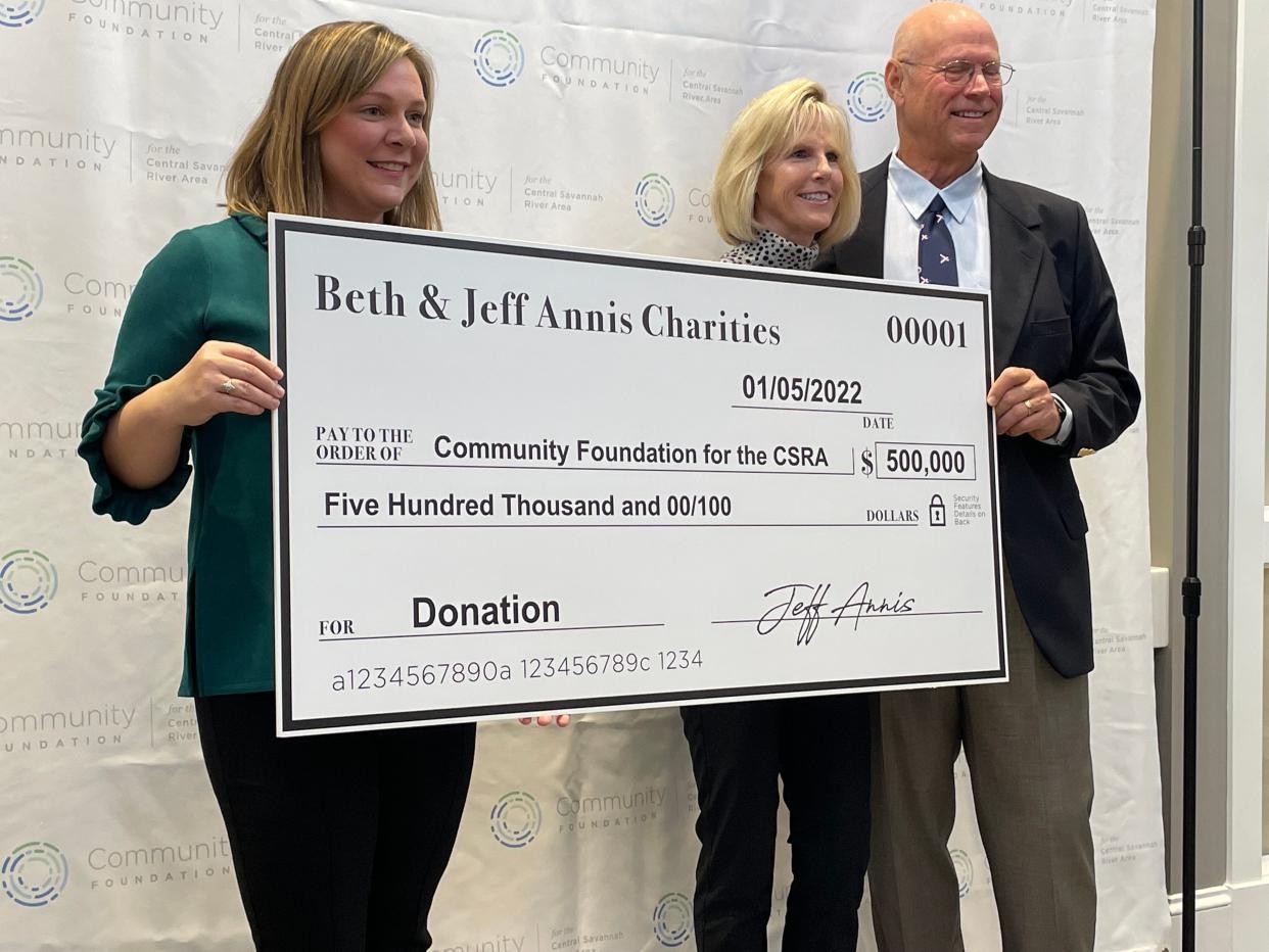 Libby Fennell (left), director of development and donor services at the Community Foundation for the Central Savannah River Area, helps Beth and Jeff Annis hold an outsized check representing a $500,000 donation aimed at helping local charities on Jan. 5, 2022, at foundation's offices in Augusta.