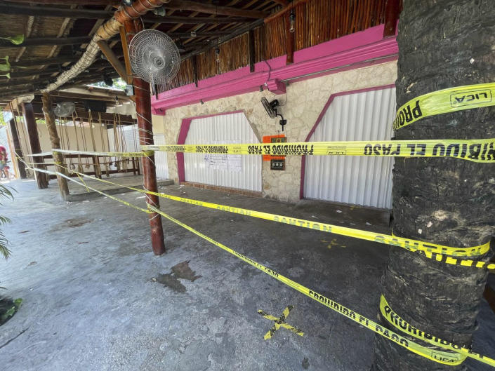 Police security tape covers the exterior of a restaurant the day after a fatal shooting in Tulum, Mexico, Friday, Oct. 22, 2021. Two foreigners were killed and three wounded in a shooting in the Mexican Caribbean resort town of Tulum. (AP Photo/Christian Rojas)