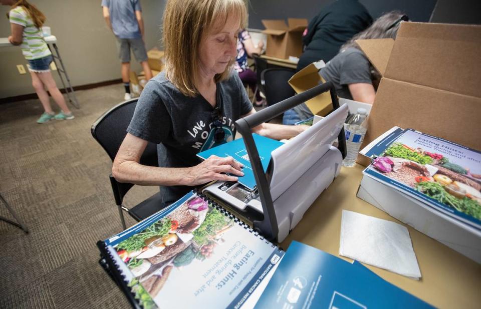 Terry Young binds educational guides at Chemo Crew’s care kit assembly project during Love Modesto community service day in Modesto, Calif., Saturday, April 29, 2023.