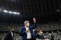 IOC President Thomas Bach wearing a face mask waves as he speaks to the media at the National Stadium, the main venue for the 2020 Olympic and Paralympic Games postponed until July 2021 due to the coronavirus pandemic, in Tokyo Tuesday, Nov. 17, 2020. Bach said during this week's trip to Tokyo that he is “encouraging” all Olympic “participants” and fans to be vaccinated - if one becomes available - if they are going to attend next year's Tokyo Olympics. (Behrouz Mehri/Pool Photo via AP)