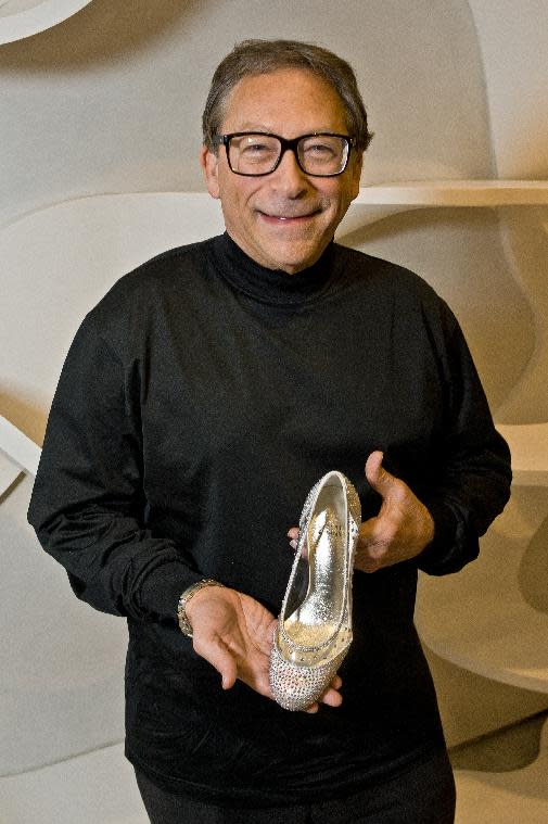 This image released by Stuart Weitzman shows the reknown shoe designer Stuart Weitzman holding a pair of glass slippers that will be worn by actress Laura Osnes in the title role of the Broadway musical, "Rodgers and Hammerstein's Cinderella on Broadway." Weitzman knows how to make shoes that make a splash. For years, he made the “million-dollar Oscar shoes,” diamond-covered footwear that a celebrity would wear to the Academy Awards. He employed a welded-construction technique that uses no screws so that Cinderella could have a seamless look. (AP Photo/Stuart Weitzman )