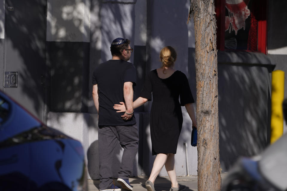 A couple hold hands as they walk to their synagogue in Los Angeles on Saturday, Oct. 7, 2023. (AP Photo/Damian Dovarganes)