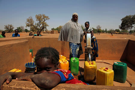 Women fill water from a pump in the village of Nedgo, near Ouagadougou, Burkina Faso February 16, 2018. REUTERS/Luc Gnago