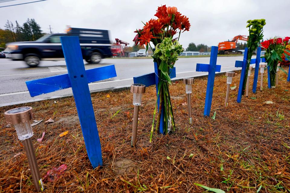 Rain-soaked memorials for those who died sit along the roadside by Schemengees Bar & Grille, Monday, Oct. 30, 2023, in Lewiston, Maine.