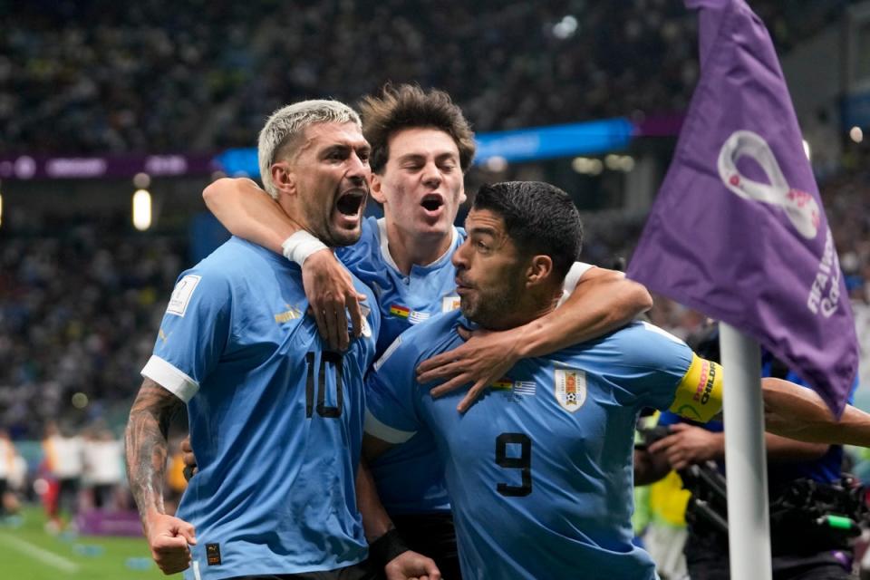 Uruguay's Giorgian de Arrascaeta, left, celebrates with teammate Luis Suarez scoring the opening goal (AP)