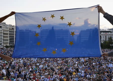 Protesters hold an EU flag as people gather at the entrance of the Greek parliament after entering its premises, during a rally calling on the government to clinch a deal with its international creditors and secure Greece's future in the Eurozone, in Athens June 18, 2015. REUTERS/Yannis Behrakis