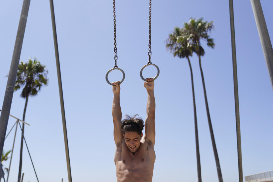 Louis Spaci, visiting from France, works out, amid triple digit temperatures in various parts of Southern California Wednesday, Aug. 31, 2022, in the Venice Beach section of Los Angeles. (AP Photo/Marcio Jose Sanchez)