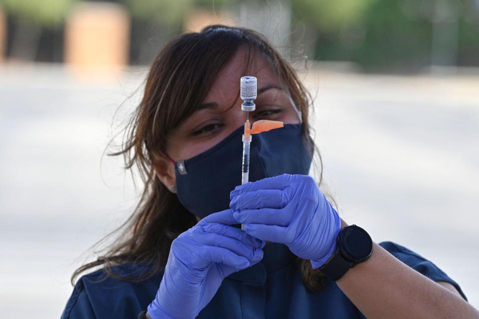 A nurse fills a syringe with Pfizer-BioNTech Covid-19 at a pop up vaccine clinic in the Arleta neighborhood of Los Angeles, California, August 23, 2021.