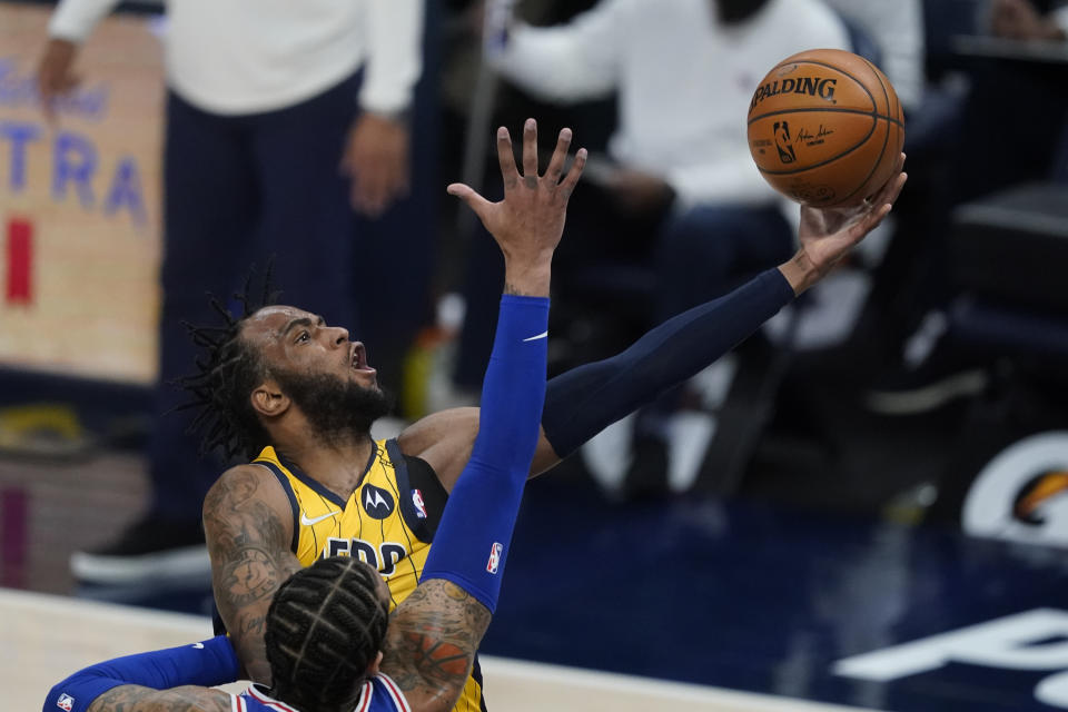 Indiana Pacers' Oshae Brissett (12) puts up a shot against Philadelphia 76ers' Mike Scott during the second half of an NBA basketball game, Tuesday, May 11, 2021, in Indianapolis. (AP Photo/Darron Cummings)