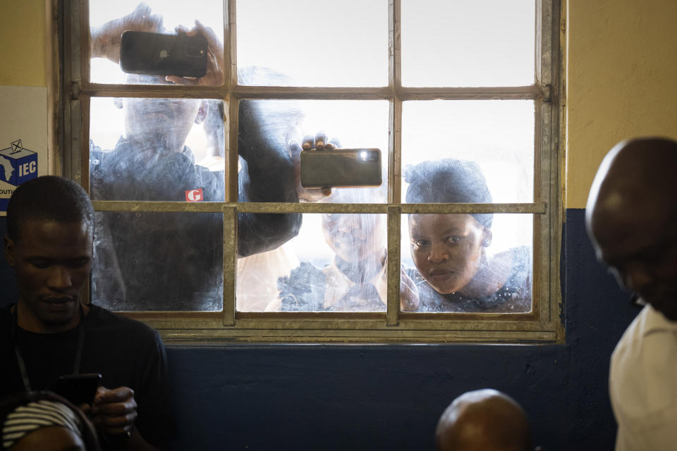 FILE - People look through a window as former president Jacob Zuma, casts his ballot on May 29, 2024 at Nkandla, Kwazulu Natal, South Africa. during general elections. South Africa is in a moment of deep soul-searching after an election that brought a jarring split from the African National Congress, the very party that gave the country freedom and democracy 30 years ago. (AP Photo/Emilio Morenatti, File)