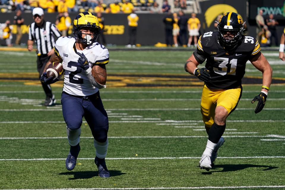 Michigan running back Blake Corum (2) runs from Iowa linebacker Jack Campbell (31) during a 20-yard touchdown run in the second half of an NCAA college football game, Saturday, Oct. 1, 2022, in Iowa City, Iowa. Michigan won 27-14. (AP Photo/Charlie Neibergall)