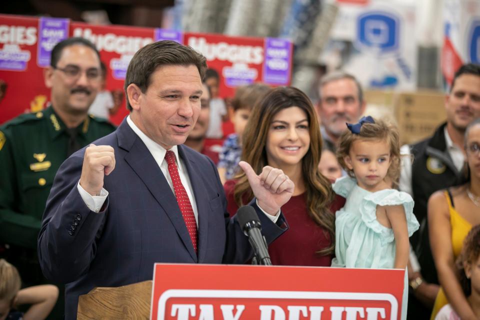 Florida Gov. Ron DeSantis announces a sales tax cut of more than $1 billon during an event on Friday at Sam’s Club in Ocala. At right is Florida first lady Casey DeSantis with their daughter, Mamie.