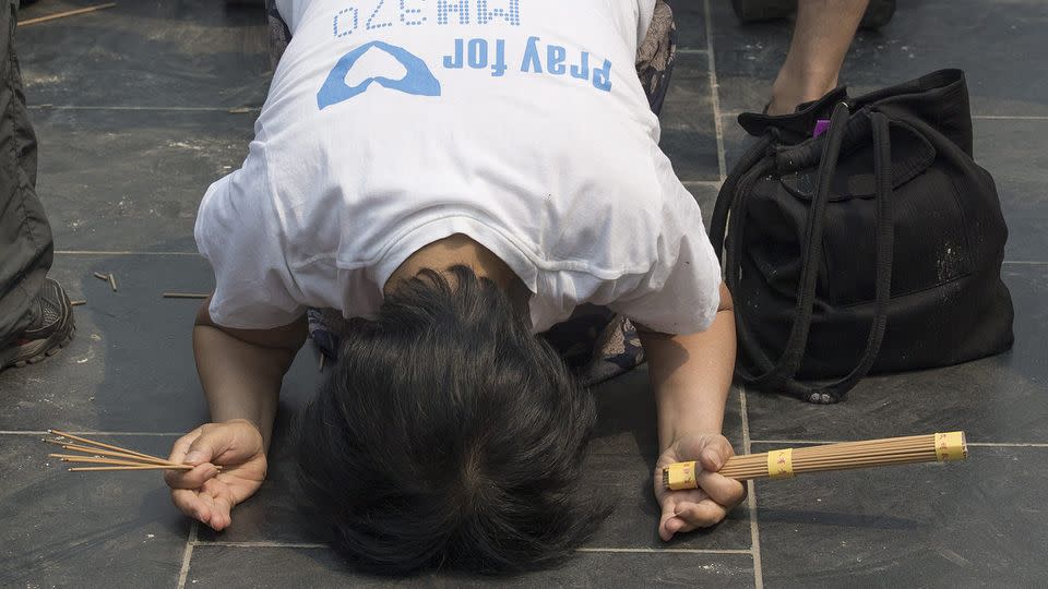 A Chinese relative of passengers of Malaysia Airlines flight MH370 prays at the Lama Temple in Beijing, China, 15 June 2014. Source: AAP