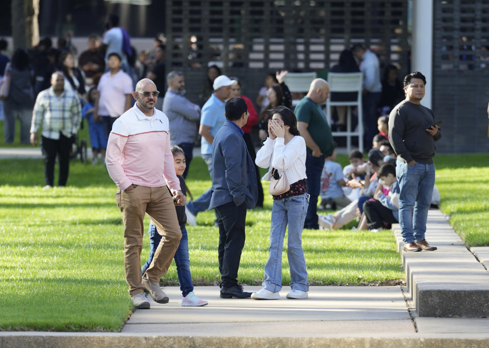 A woman holds her face as she waits with others outside Lakewood Church, Sunday, Feb. 11, 2024, in Houston, after a reported shooting during a Spanish church service. (Karen Warren/Houston Chronicle via AP)