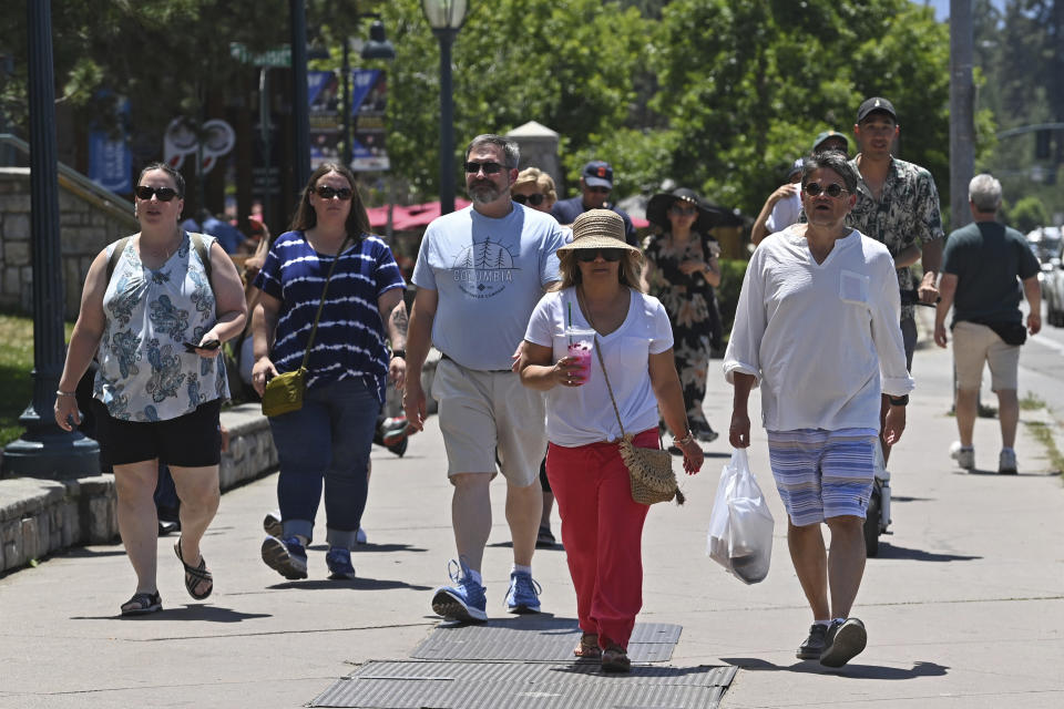 People walk along lake Tahoe Boulevard in South Lake Tahoe, Calif., Monday, July 17, 2023. Tourism officials at Lake Tahoe were surprised, and a bit standoffish, when a respected international travel guide included the iconic alpine lake straddling the California line on a list of places to stay away from this year because of the harmful ecological effects of “over-tourism.” (AP Photo/Andy Barron)