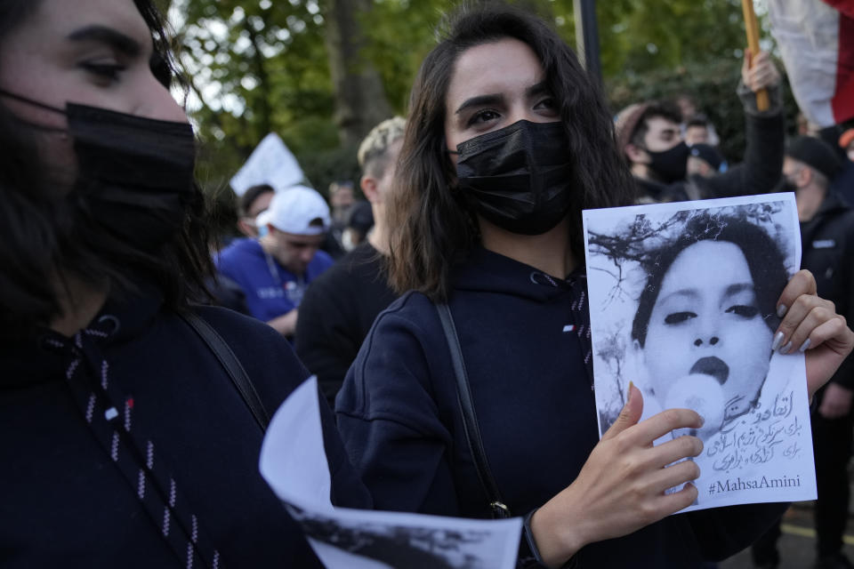 Demonstrators hold placards outside the Iranian Embassy in London, Sunday, Sept. 25, 2022. They were protesting against the death of Iranian Mahsa Amini, a 22-year-old woman who died in Iran while in police custody, who was arrested by Iran's morality police for allegedly violating its strictly-enforced dress code. (AP Photo/Alastair Grant)