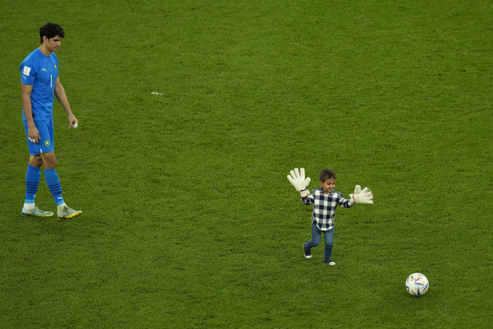 El portero marroquí Yassine Bounou mira a su hijo jugar tras la victoria ante Portugal en los cuartos de final del Mundial, el sábado 10 de diciembre de 2022, en Doha, Qatar. (AP Foto/Alessandra Tarantino)