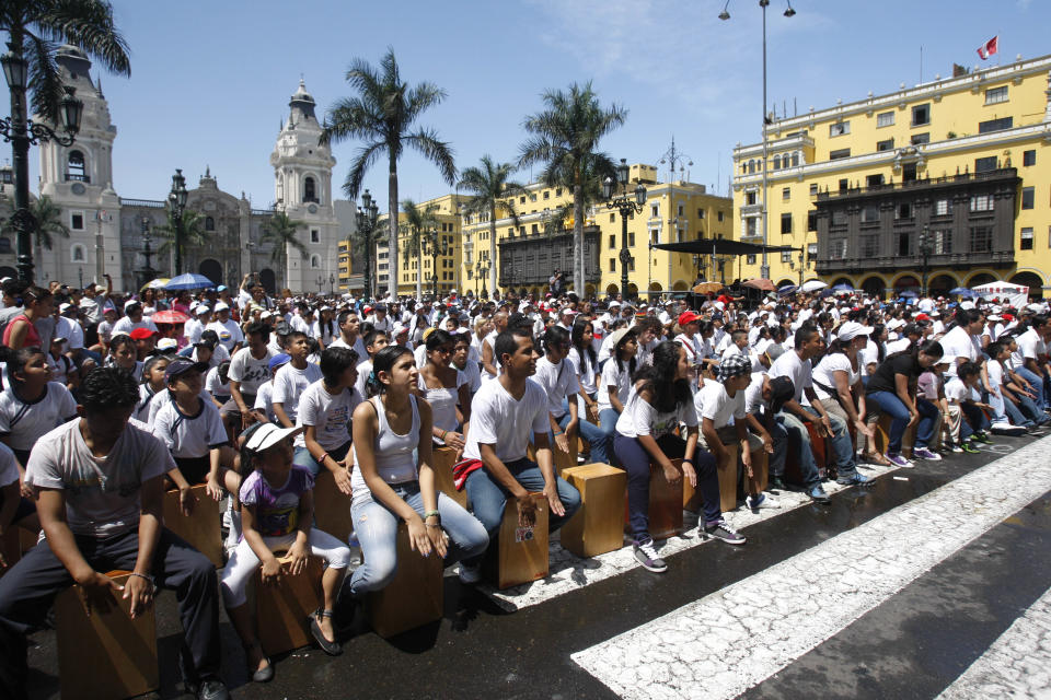 FILE - This April 14, 2012 file photo shows participants playing their cajons, a box-shaped percussion instrument of Afro-Peruvian origin, in hopes of beating their country's 2009 Guinness World Record for the world's largest cajon ensemble during the Fifth International Festival of the Peruvian Cajon at the Plaza de Armas in Lima, Peru. (AP Photo/Karel Navarro, file)