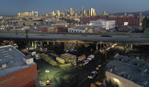 Crews continue to clear debris and shore up a stretch of Interstate 10, Tuesday morning Nov. 14, 2023, in Los Angeles. It will take at least three weeks to repair the Los Angeles freeway damaged in an arson fire, the California Gov. Gavin Newsom said Tuesday, leaving the city already accustomed to soul-crushing traffic without part of a vital artery that serves hundreds of thousands of people daily. (Dean Musgrove/The Orange County Register via AP)