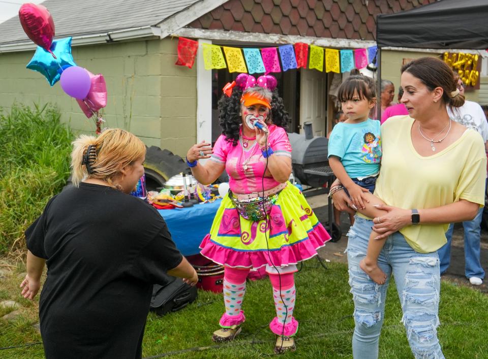 La Payacita Lucy the clown, 55, Coss Y Leon, entertains Kimeecha Rivera, right, and one of Rivera's twin daughters Ivette, 3, at a birthday party in Milwaukee. Leon has been in the clown business for 20 years.