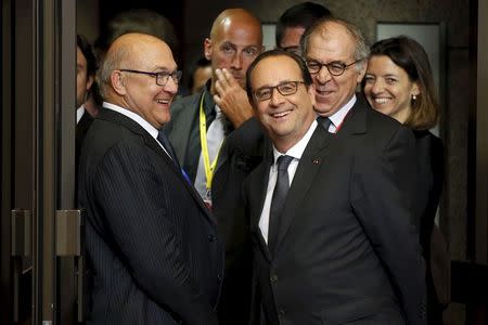 France's President Francois Hollande (C) and Finance minister Michel Sapin (L) react as they leave the European Commission after a meeting ahead of a Eurozone emergency summit on Greece in Brussels, Belgium late June 22, 2015. REUTERS/Charles Platiau