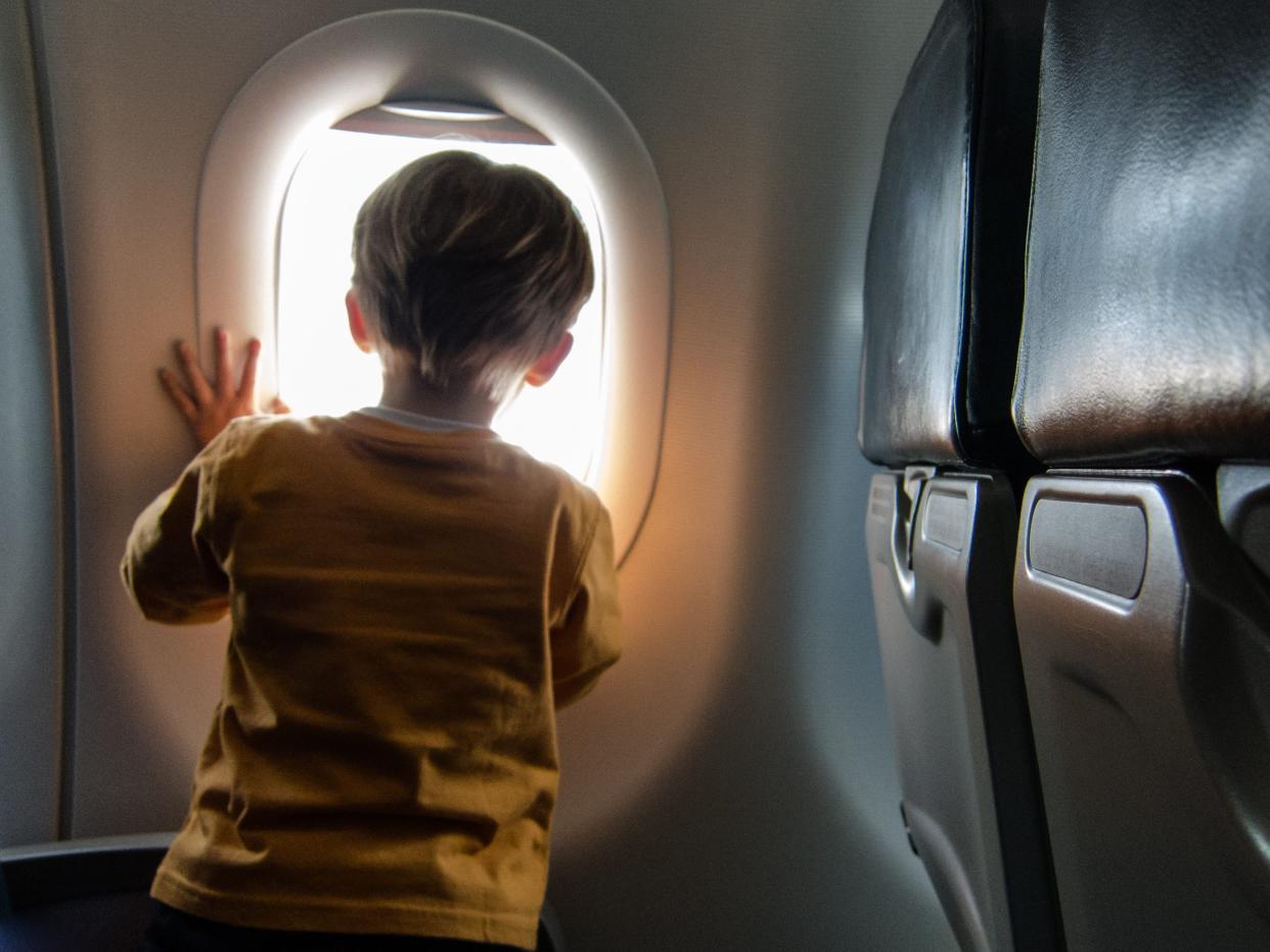 Toddler looking through an airplane window