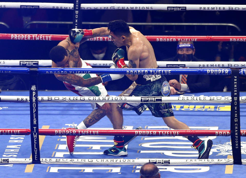 Gervonta Davis, left, is knocked down by Leo Santa Cruz during the first round of a boxing bout Saturday, Oct. 31, 2020, in San Antonio. (AP Photo/Ronald Cortes)